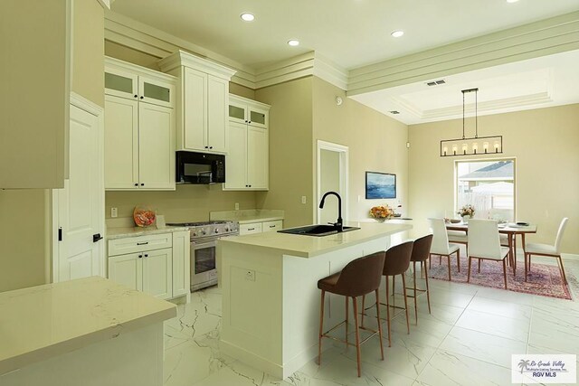 8801 Swan Lake Dr # 24, Harlingen, TX 78552 - kitchen featuring marble finish floor, a center island with sink, a sink, black microwave, and high end range