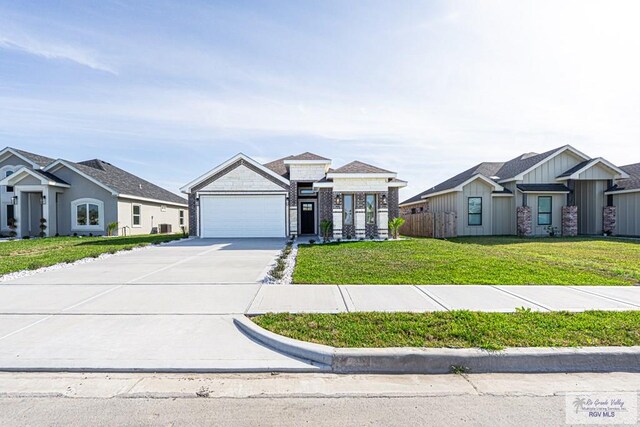 8801 Swan Lake Dr # 24, Harlingen, TX 78552 - view of front of home featuring an attached garage, brick siding, concrete driveway, and a front yard