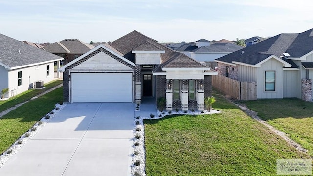 8801 Swan Lake Dr # 24, Harlingen, TX 78552 - view of front facade featuring concrete driveway, an attached garage, fence, a residential view, and a front lawn