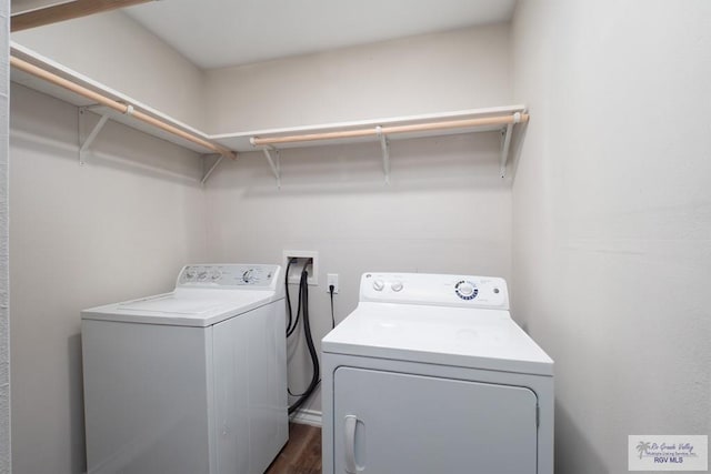 washroom with washing machine and dryer and dark hardwood / wood-style floors