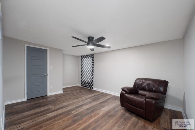 living area featuring ceiling fan and dark hardwood / wood-style floors