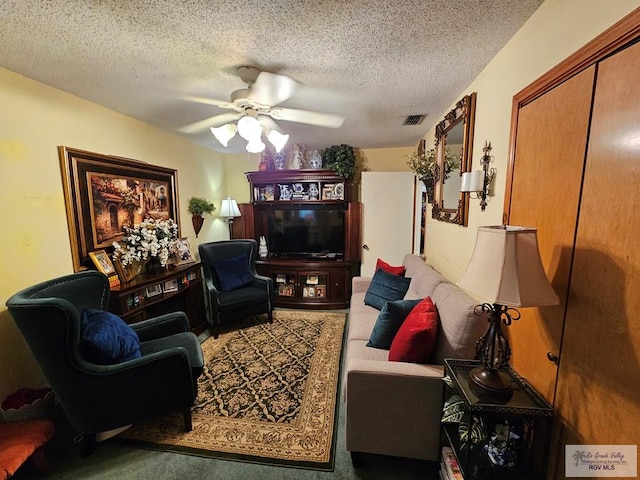 living room featuring carpet, a textured ceiling, and ceiling fan