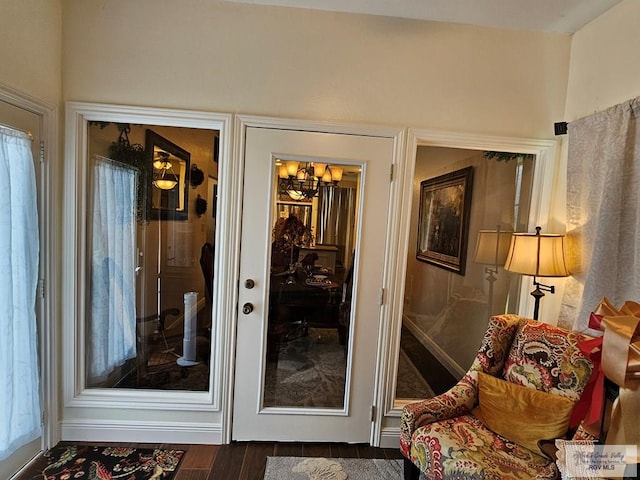 entryway with a notable chandelier and dark hardwood / wood-style flooring