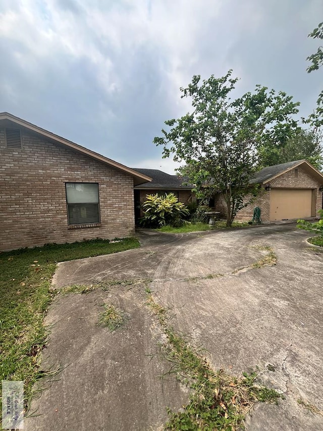 35 Alvarado Ave, Rancho Viejo, TX 78575 - mid-century home featuring brick siding, driveway, and an attached garage