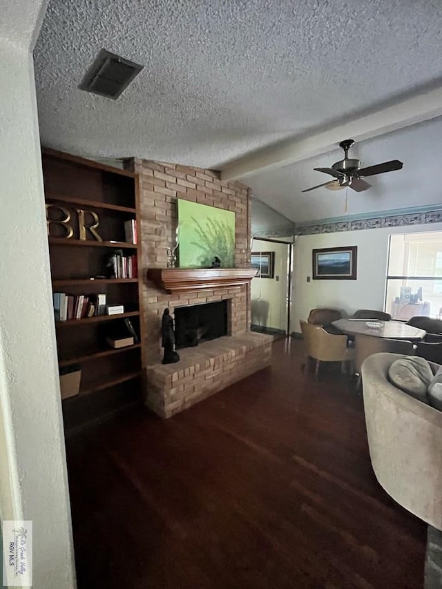 35 Alvarado Ave, Rancho Viejo, TX 78575 - living room featuring wood finished floors, a fireplace, a textured ceiling, and a ceiling fan