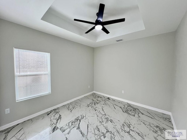 406 Valle Alto Dr, Los Fresnos, TX 78566 - spare room featuring a tray ceiling, marble finish flooring, and a ceiling fan