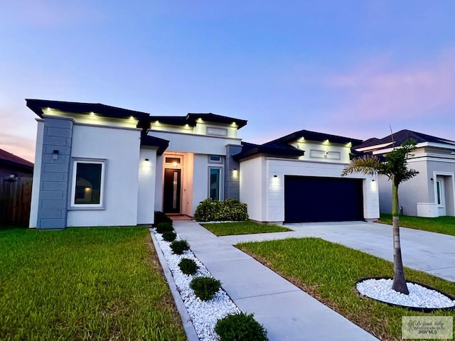 406 Valle Alto Dr, Los Fresnos, TX 78566 - contemporary home featuring driveway, a garage, a lawn, and stucco siding