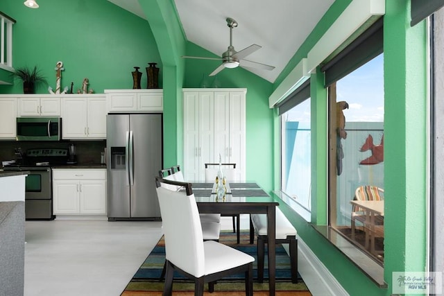 kitchen featuring stainless steel appliances, vaulted ceiling, tasteful backsplash, ceiling fan, and white cabinets