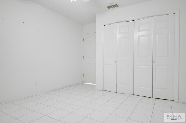 unfurnished bedroom with a closet and light tile patterned floors