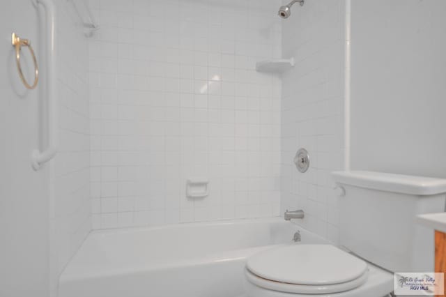 full bathroom featuring tiled shower / bath, vanity, and toilet