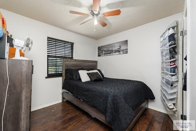 bedroom featuring a ceiling fan, baseboards, and wood finished floors