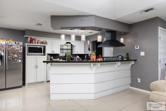 kitchen with appliances with stainless steel finishes, white cabinetry, visible vents, and range hood