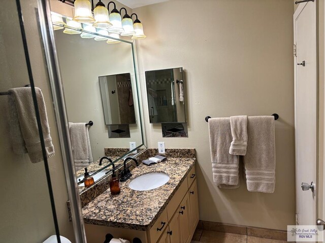 110 Padre Blvd Unit 407, South Padre Island, TX 78597 - bathroom with vanity, baseboards, tile patterned flooring, and an inviting chandelier