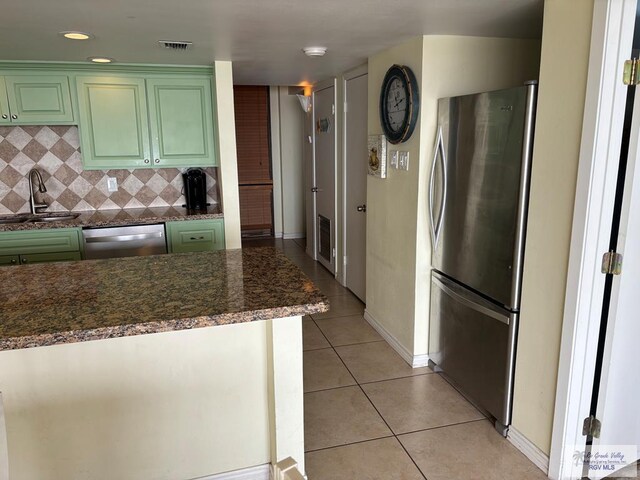 110 Padre Blvd Unit 407, South Padre Island, TX 78597 - kitchen with green cabinetry, stainless steel appliances, visible vents, light tile patterned floors, and a sink