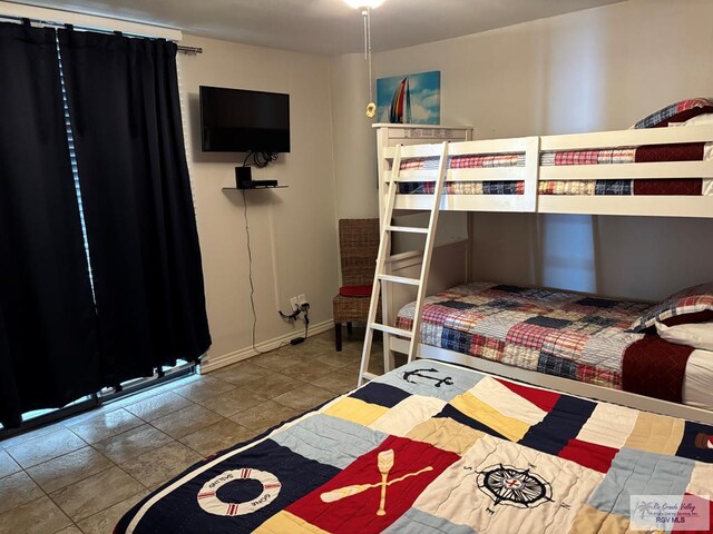 110 Padre Blvd Unit 407, South Padre Island, TX 78597 - bedroom featuring baseboards and tile patterned flooring