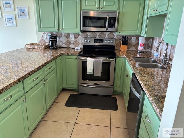110 Padre Blvd Unit 407, South Padre Island, TX 78597 - kitchen featuring light tile patterned floors, tasteful backsplash, stainless steel appliances, and a sink