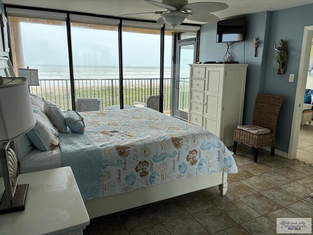 110 Padre Blvd Unit 407, South Padre Island, TX 78597 - bedroom featuring expansive windows, stone finish flooring, and access to exterior
