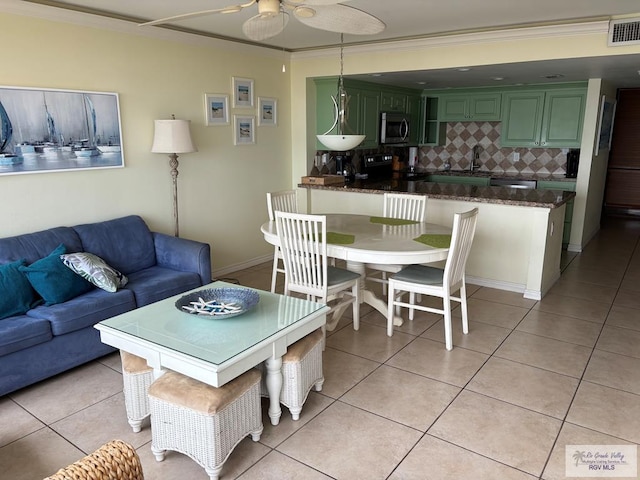 dining space featuring ornamental molding, a ceiling fan, visible vents, and light tile patterned floors