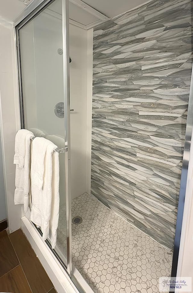 bathroom with hardwood / wood-style floors and walk in shower