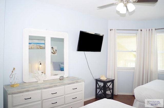 bedroom featuring dark hardwood / wood-style floors, multiple windows, and ceiling fan