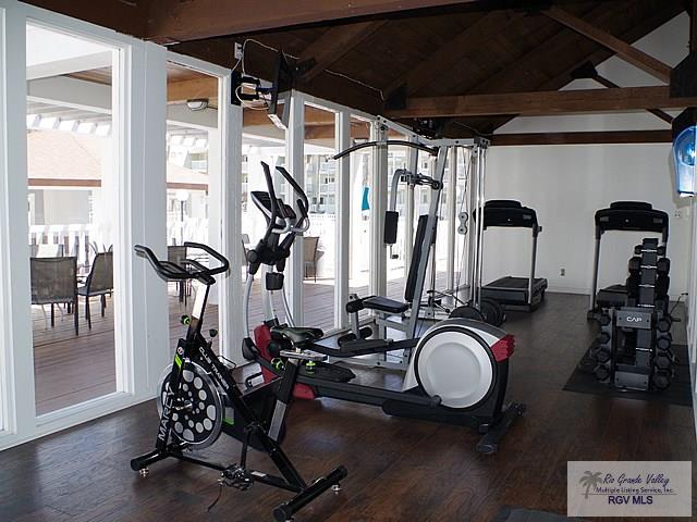 gym featuring dark wood-type flooring and lofted ceiling