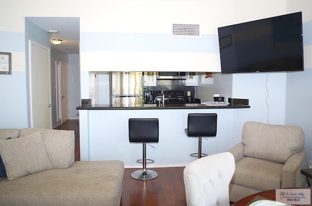 200 Padre Blvd Unit A314 1314, South Padre Island, TX 78597 - kitchen with appliances with stainless steel finishes, dark countertops, wood finished floors, a breakfast bar area, and a peninsula