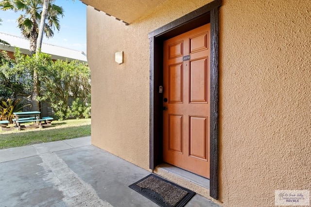 doorway to property featuring stucco siding