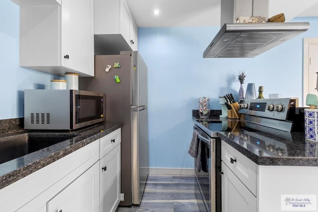 kitchen with white cabinets, island range hood, stainless steel appliances, baseboards, and wood finished floors