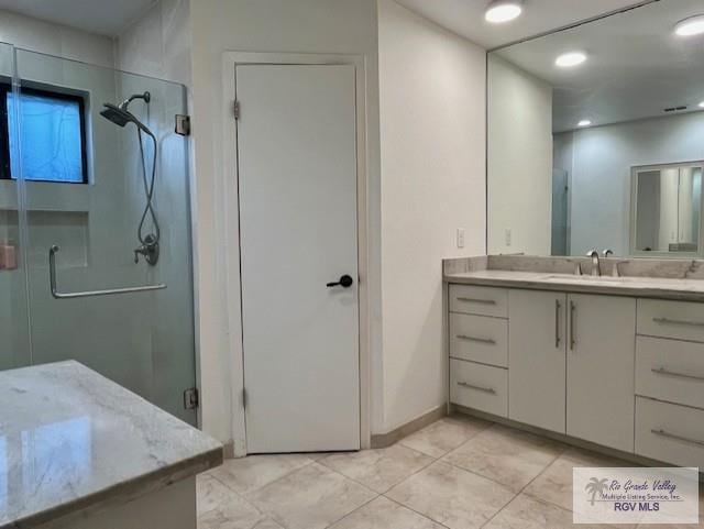 bathroom featuring vanity and a shower with shower door