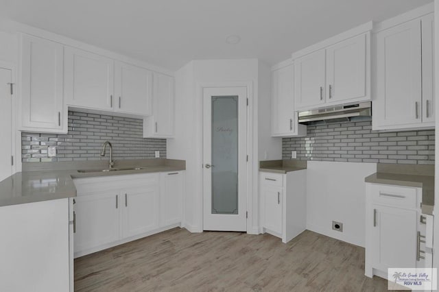 kitchen featuring white cabinetry, sink, and light wood-type flooring