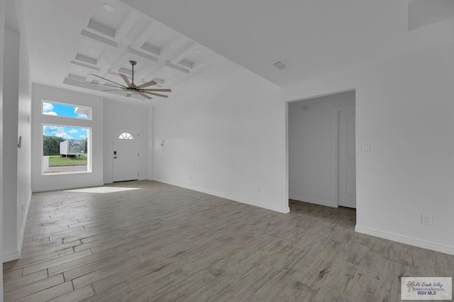 empty room featuring ceiling fan, beamed ceiling, light hardwood / wood-style floors, and coffered ceiling