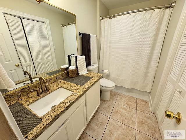 bathroom with tile patterned floors, vanity, curtained shower, and toilet