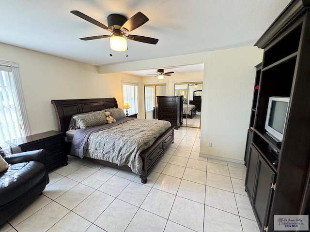 bedroom featuring multiple windows, ceiling fan, and light tile patterned flooring