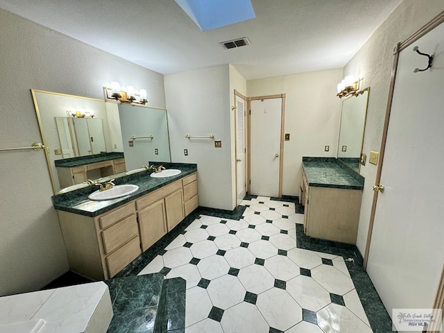 bathroom with a skylight and vanity