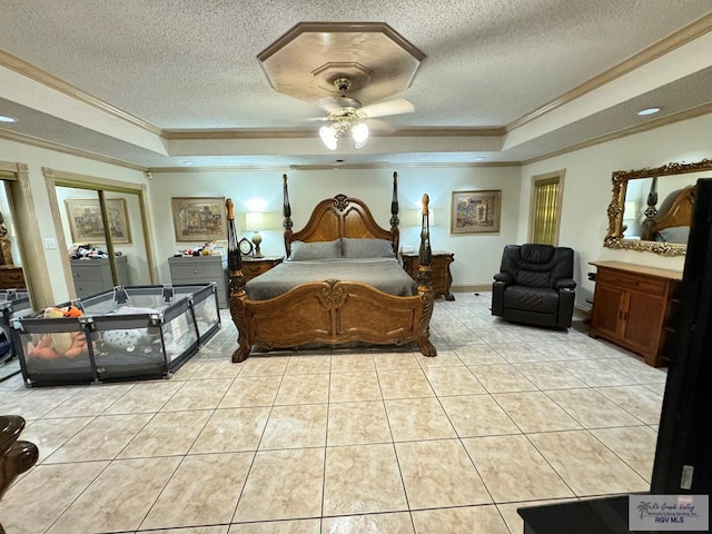 tiled bedroom with ceiling fan, ornamental molding, a textured ceiling, and a tray ceiling