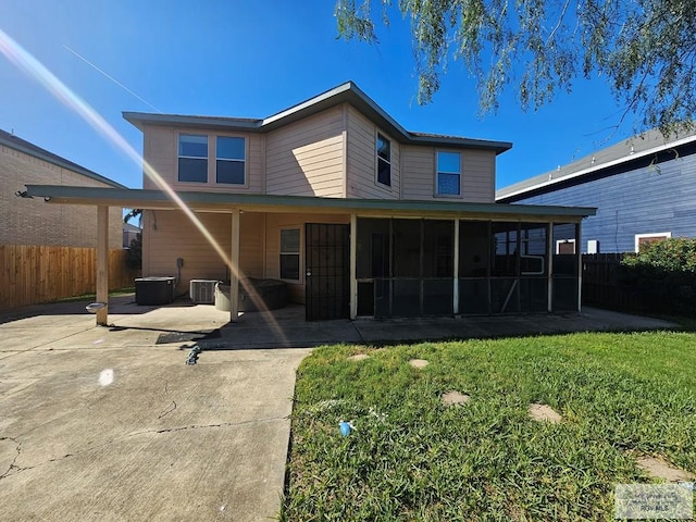 1149 Champlain Dr, Brownsville, TX 78526 - back of property with a lawn, a sunroom, and a patio