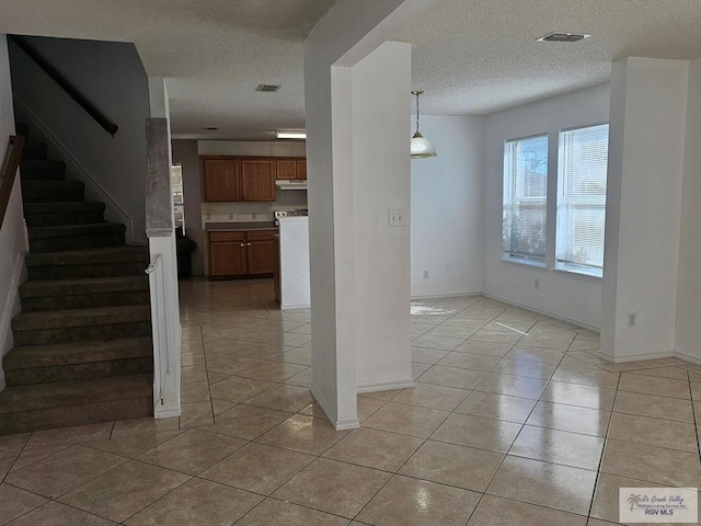 interior space featuring a textured ceiling and tile patterned floors