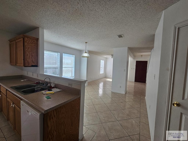 1149 Champlain Dr, Brownsville, TX 78526 - kitchen featuring dishwasher, sink, kitchen peninsula, a textured ceiling, and light tile patterned floors