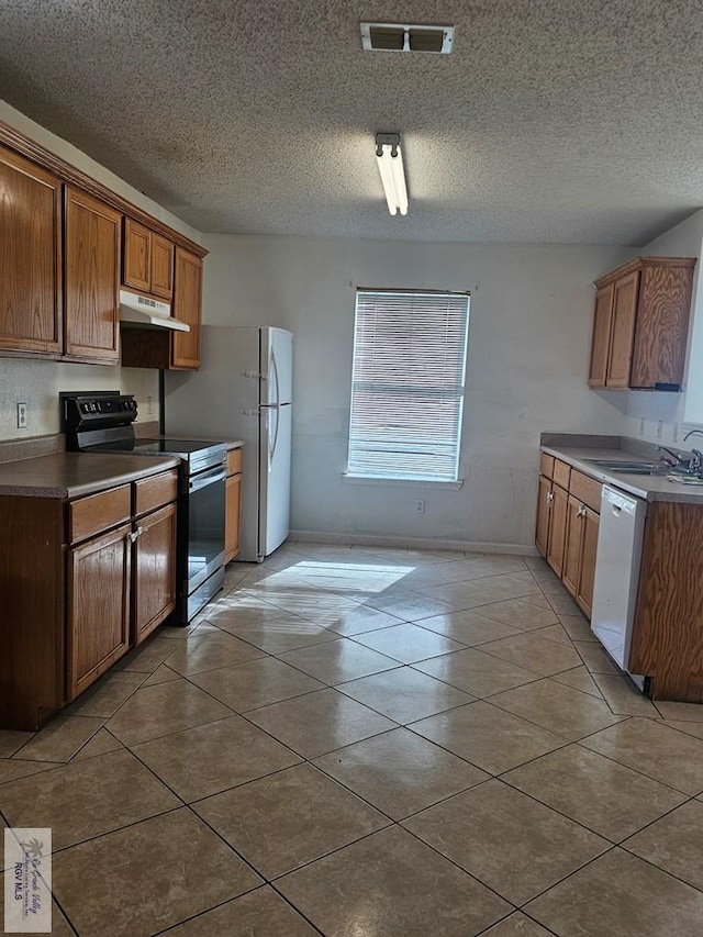 1149 Champlain Dr, Brownsville, TX 78526 - kitchen with dishwasher, black electric range oven, light tile patterned floors, and sink