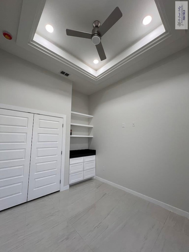 walk in closet featuring a ceiling fan, a raised ceiling, visible vents, and marble finish floor