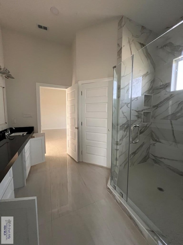 full bathroom featuring visible vents, vanity, and a marble finish shower