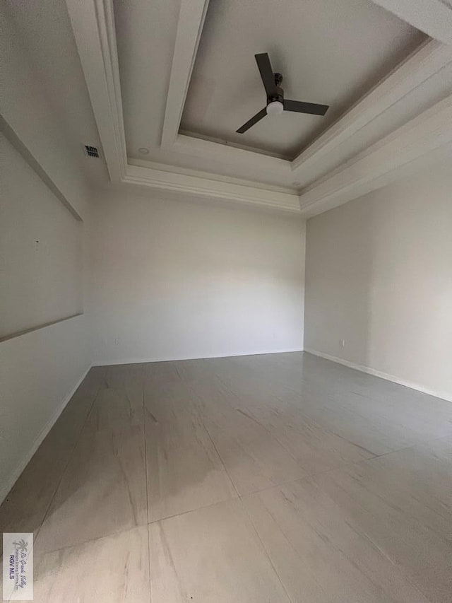 unfurnished room with ceiling fan, a tray ceiling, and visible vents