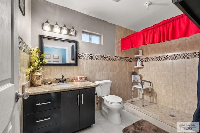 bathroom featuring toilet, a shower, tile walls, vanity, and tile patterned flooring