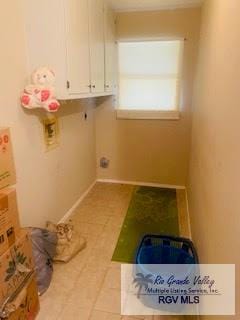 laundry area with light tile patterned floors