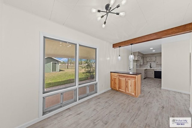 1909 E Madison Ave, Harlingen, TX 78550 - kitchen featuring a peninsula, a chandelier, light wood-style flooring, backsplash, and baseboards