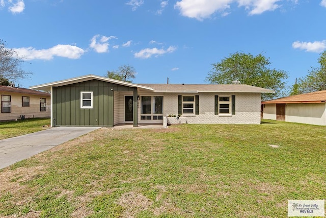1909 E Madison Ave, Harlingen, TX 78550 - ranch-style home with board and batten siding, a front lawn, brick siding, and concrete driveway