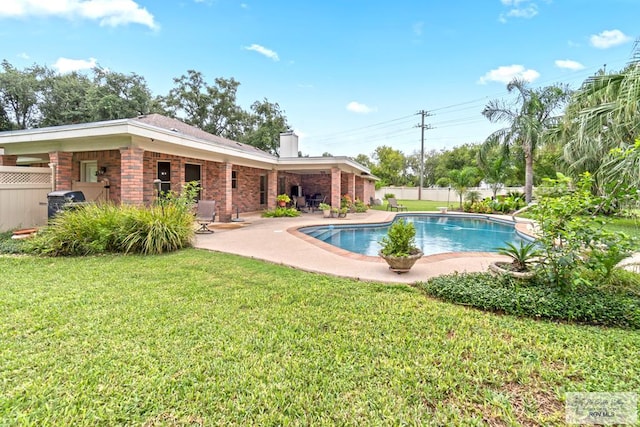 view of swimming pool with a grill, a yard, and a patio