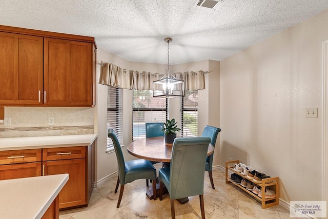 dining space featuring a textured ceiling and a notable chandelier