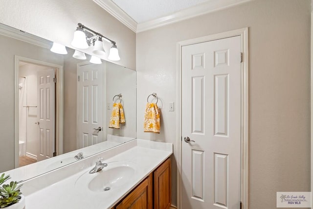 bathroom with vanity, a textured ceiling, and ornamental molding