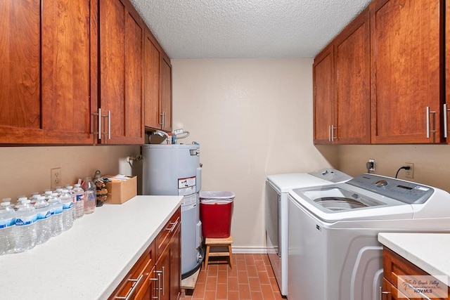 laundry area featuring water heater, washer and dryer, cabinets, and a textured ceiling